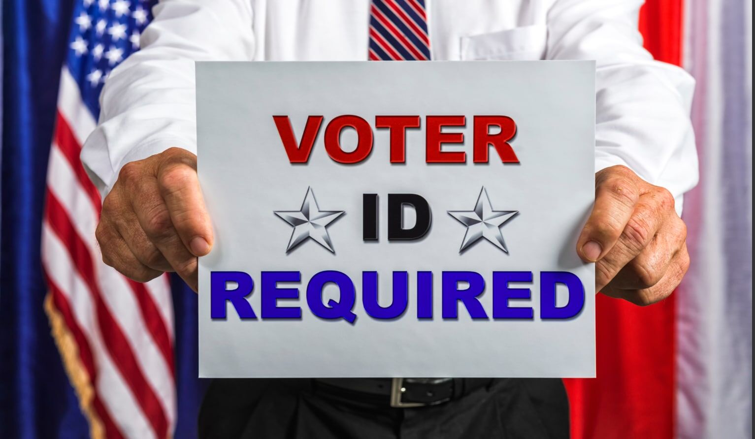 Businessman holding a sign that reads Voter ID Required Man holding "Voter ID Required" sign