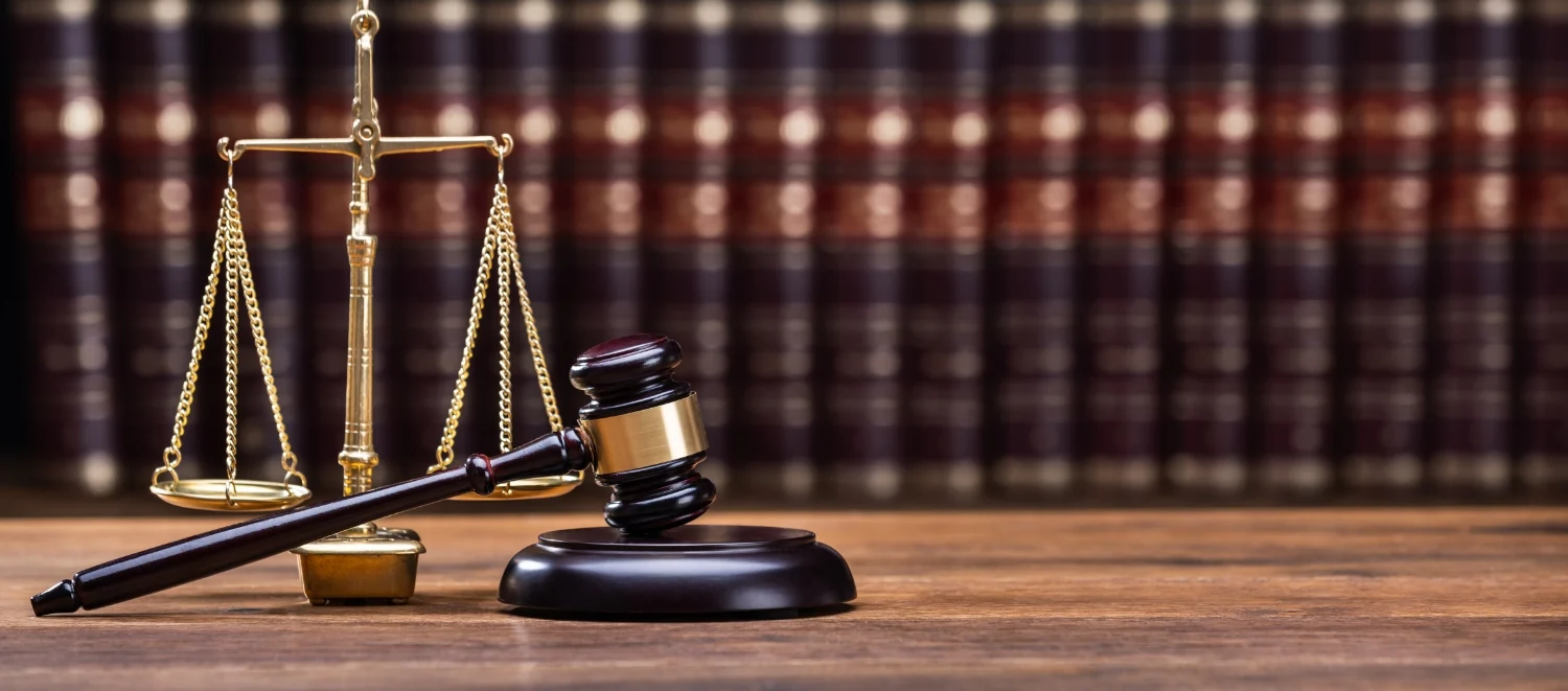 Photo of a gavel in front of the scales of justice