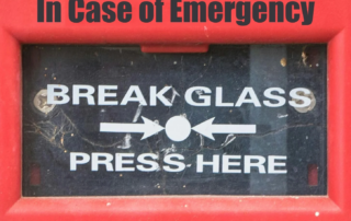 Image of an alarm that reads, "In case of emergency, break glass. Press here."