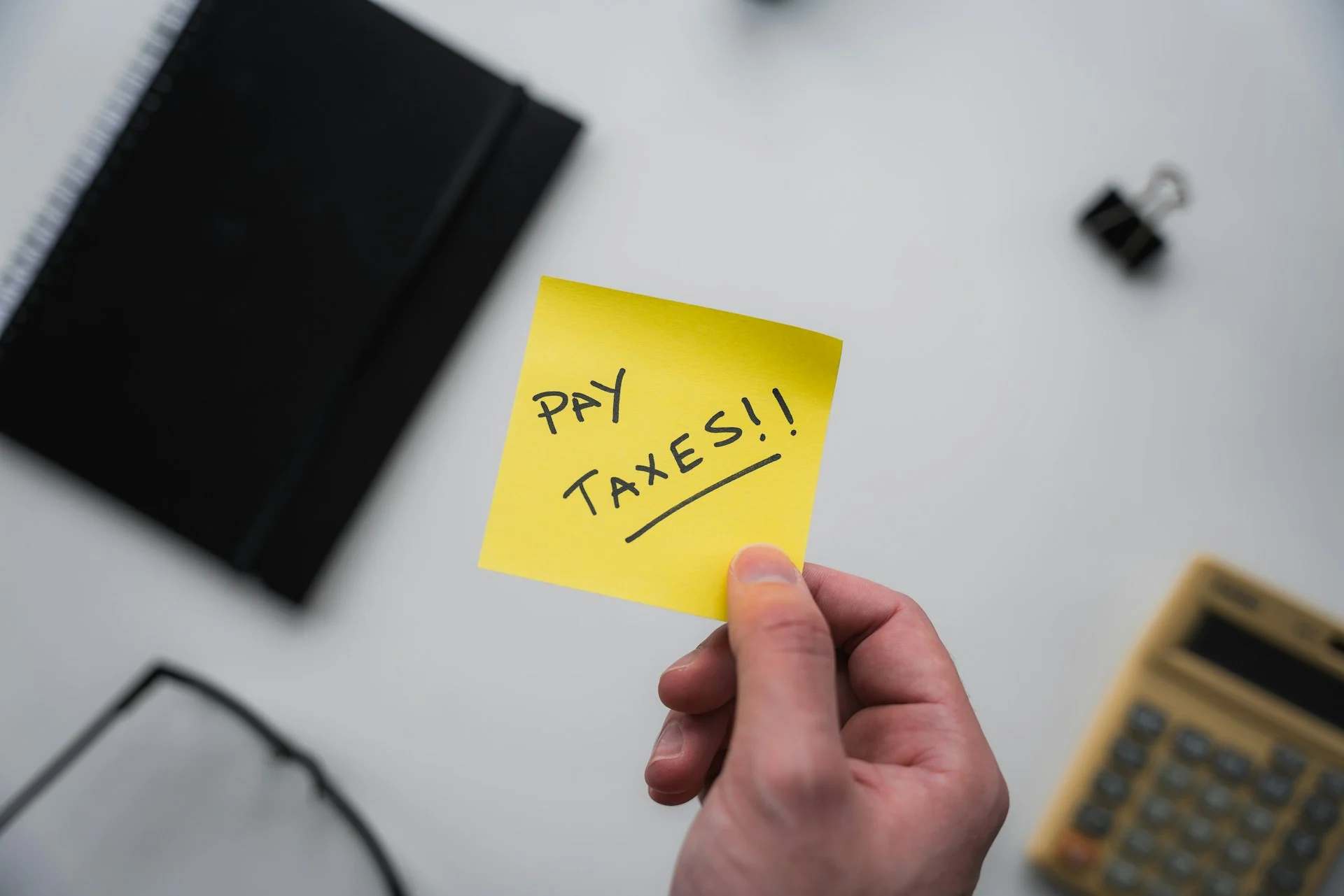 PostIt note with reminder to "Pay Taxes!!"