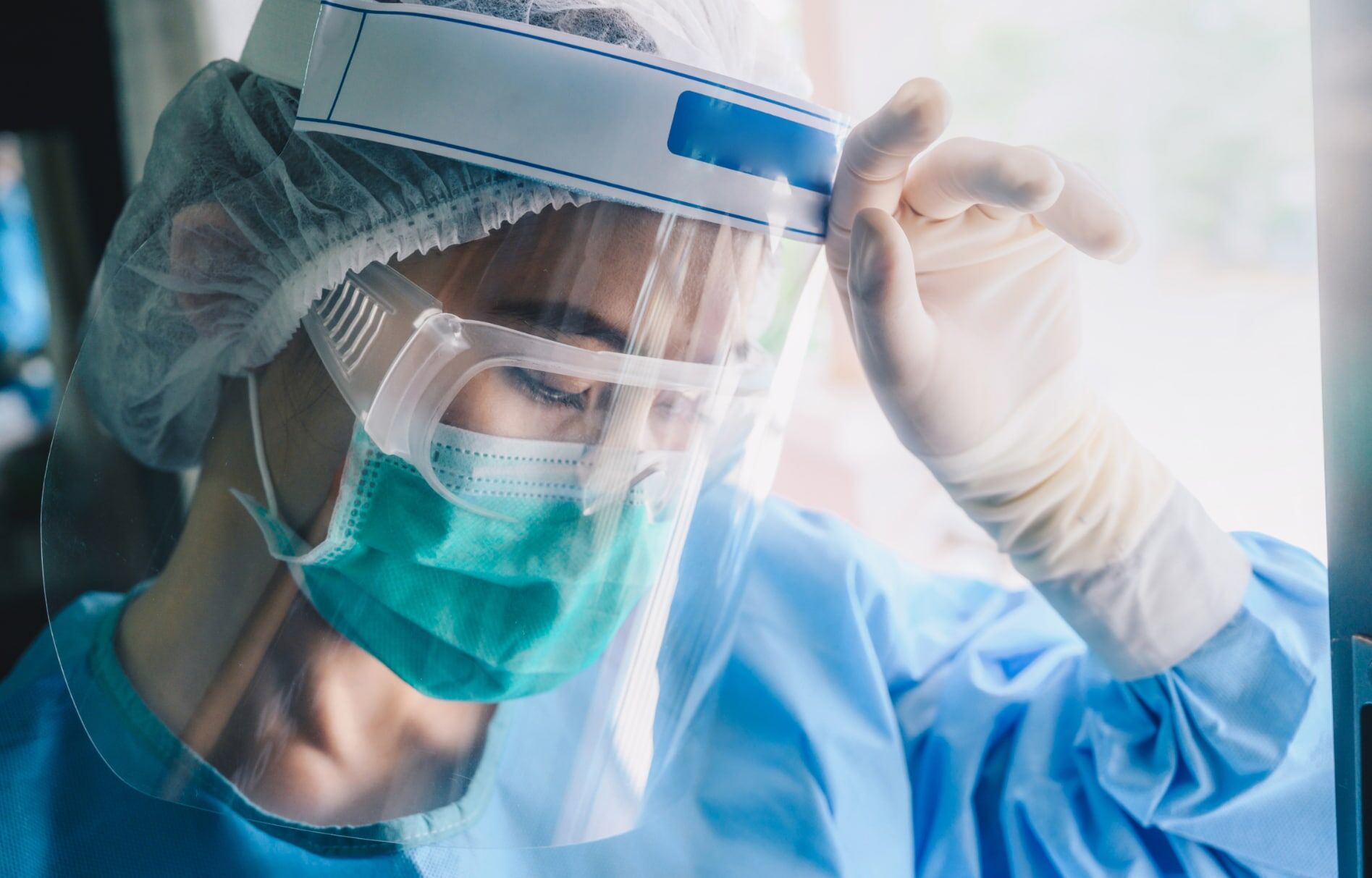 Nurse having headache and tired from work while wearing PPE suit for protect coronavirus disease. Nurse tired and with headache from wearing PPE
