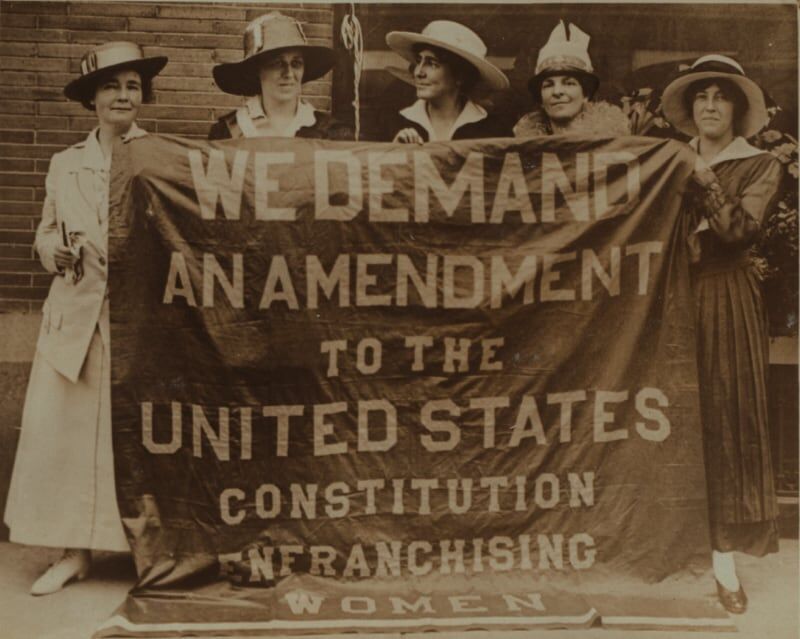 Women holding a sign demanding an amendment to the Constitution