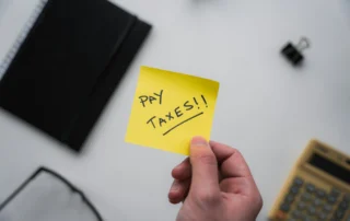 PostIt note with reminder to "Pay Taxes!!"